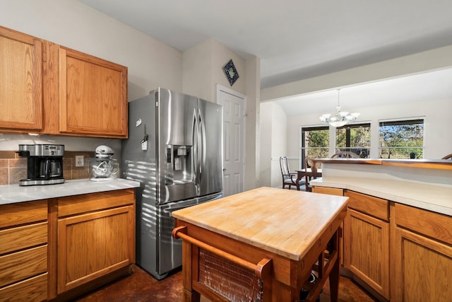 1726 Bowler Rd, Waller, TX 77484 - kitchen with stainless steel refrigerator with ice dispenser, a chandelier, brown cabinets, wooden counters, and pendant lighting