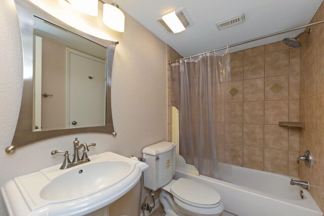 2611 Grants Lake Blvd Unit 222, Sugar Land, TX 77479 - bathroom with a sink, toilet, shower / tub combo with curtain, and a textured wall