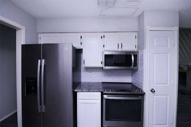 23303 Calico Corners Ln, Spring, TX 77373 - kitchen featuring stainless steel appliances, white cabinets, a textured ceiling, backsplash, and dark stone countertops