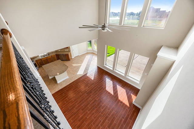 20522 Saddleback Chase Ln, Cypress, TX 77433 - unfurnished living room featuring a high ceiling, a sink, a ceiling fan, baseboards, and wood finished floors
