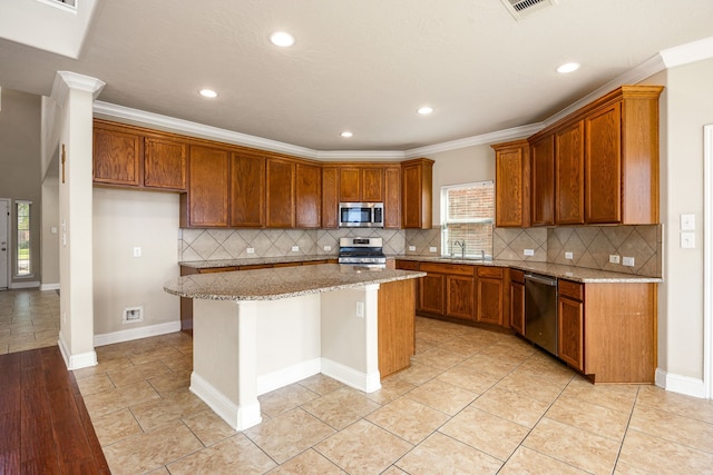 20522 Saddleback Chase Ln, Cypress, TX 77433 - kitchen with stainless steel appliances, a kitchen island, brown cabinets, light stone countertops, and recessed lighting