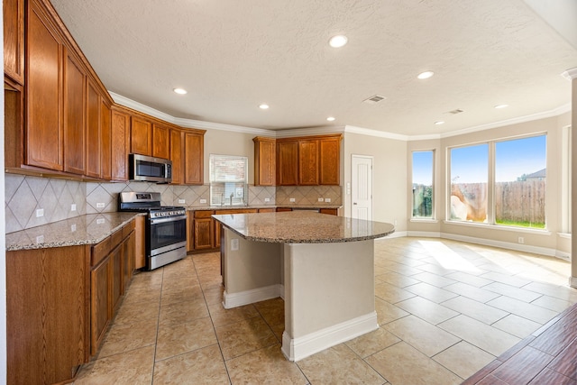 20522 Saddleback Chase Ln, Cypress, TX 77433 - kitchen featuring appliances with stainless steel finishes, recessed lighting, brown cabinets, a sink, and a center island