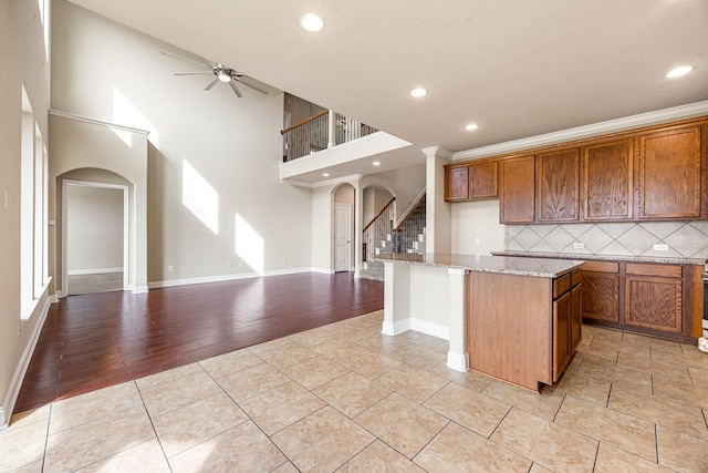 20522 Saddleback Chase Ln, Cypress, TX 77433 - kitchen featuring arched walkways, a ceiling fan, decorative backsplash, a kitchen island, and open floor plan