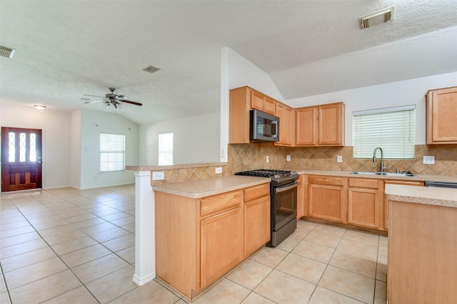 5811 Laramie River Ct, Katy, TX 77449 - kitchen featuring range with gas stovetop, vaulted ceiling, a sink, stainless steel microwave, and light tile patterned flooring