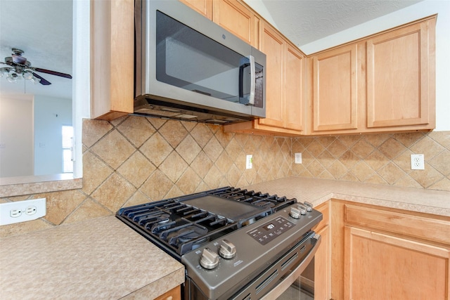 5811 Laramie River Ct, Katy, TX 77449 - kitchen with stainless steel appliances, light brown cabinetry, light countertops, ceiling fan, and tasteful backsplash