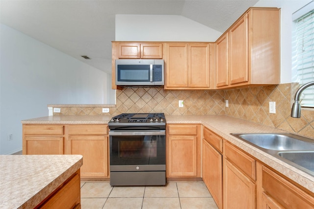 5811 Laramie River Ct, Katy, TX 77449 - kitchen featuring appliances with stainless steel finishes, a sink, light brown cabinets, lofted ceiling, and decorative backsplash