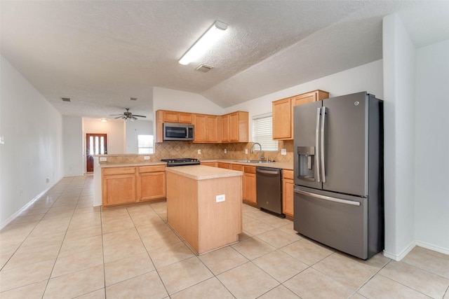 5811 Laramie River Ct, Katy, TX 77449 - kitchen with stainless steel appliances, a sink, vaulted ceiling, light countertops, and tasteful backsplash