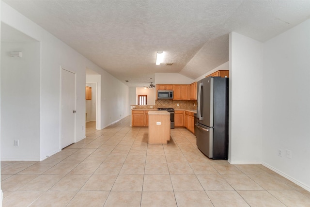 5811 Laramie River Ct, Katy, TX 77449 - kitchen with stainless steel appliances, lofted ceiling, a center island, decorative backsplash, and light countertops