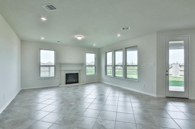 28430 Buffalo Fork Ln, Katy, TX 77494 - unfurnished living room featuring baseboards, a glass covered fireplace, light tile patterned floors, and recessed lighting