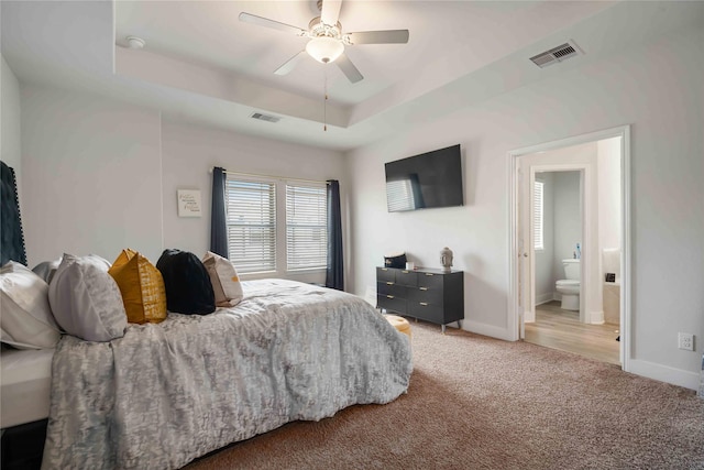 4426 Ibiza Ln, Houston, TX 77045 - bedroom with a raised ceiling, multiple windows, light carpet, and a ceiling fan