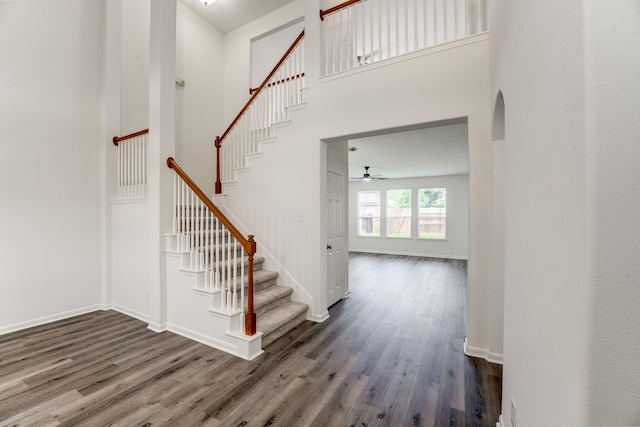 16906 Shoal Park Dr, Cypress, TX 77429 - staircase featuring wood finished floors, ceiling fan, arched walkways, baseboards, and a towering ceiling