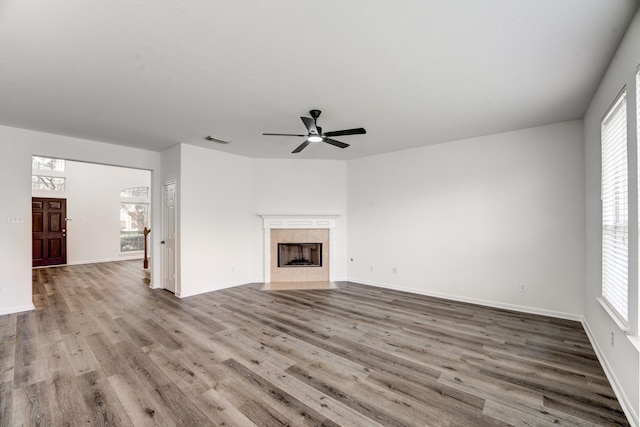 16906 Shoal Park Dr, Cypress, TX 77429 - unfurnished living room featuring wood finished floors, ceiling fan, baseboards, and a tiled fireplace