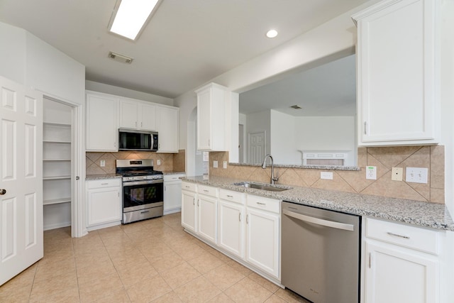 16906 Shoal Park Dr, Cypress, TX 77429 - kitchen featuring stainless steel appliances, a sink, tasteful backsplash, white cabinets, and recessed lighting