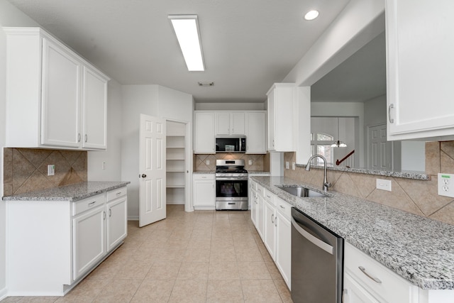 16906 Shoal Park Dr, Cypress, TX 77429 - kitchen with stainless steel appliances, a sink, decorative backsplash, white cabinets, and recessed lighting