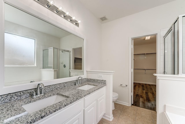 16906 Shoal Park Dr, Cypress, TX 77429 - full bath featuring a spacious closet, a stall shower, toilet, double vanity, and tile patterned floors