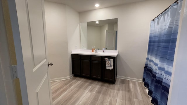 21138 Titian Dr, Magnolia, TX 77355 - bathroom with wood finished floors, vanity, baseboards, and recessed lighting