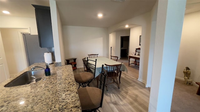 21138 Titian Dr, Magnolia, TX 77355 - kitchen with a sink, arched walkways, freestanding refrigerator, light stone countertops, and recessed lighting