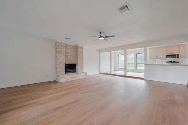 8014 Wray Ct, Houston, TX 77088 - unfurnished living room featuring ceiling fan, crown molding, light wood-style flooring, a brick fireplace, and baseboards