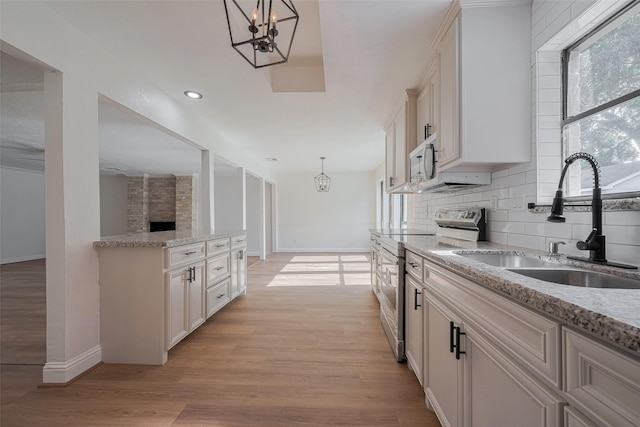 8014 Wray Ct, Houston, TX 77088 - kitchen featuring stainless steel range with electric cooktop, a sink, baseboards, a chandelier, and decorative light fixtures
