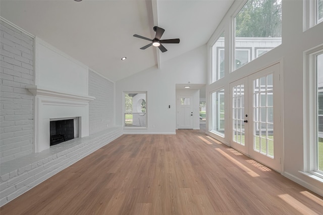 19467 Enchanted Stream Dr, Spring, TX 77388 - unfurnished living room featuring light wood-style floors, high vaulted ceiling, a brick fireplace, ceiling fan, and healthy amount of natural light