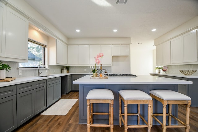 6014 Franz Ct, Katy, TX 77493 - kitchen with gray cabinetry, a sink, a kitchen bar, backsplash, and recessed lighting