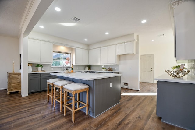 6014 Franz Ct, Katy, TX 77493 - kitchen featuring dark wood-style flooring, light countertops, a kitchen island, white cabinets, and recessed lighting