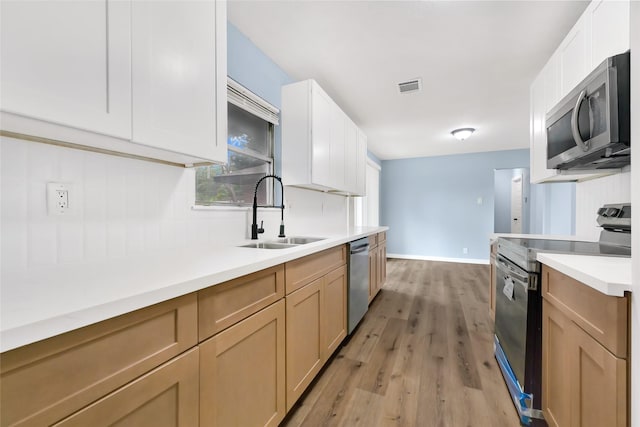 627 Edgebrook Dr, Houston, TX 77034 - kitchen featuring appliances with stainless steel finishes, a sink, light wood-style floors, light countertops, and baseboards