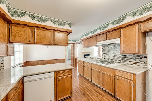 6310 Ash Oak Dr, Houston, TX 77091 - kitchen featuring white appliances, under cabinet range hood, light wood-type flooring, and decorative backsplash