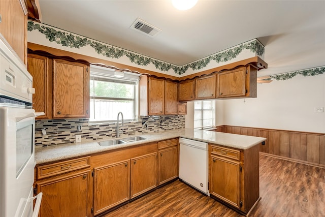 6310 Ash Oak Dr, Houston, TX 77091 - kitchen featuring white appliances, a sink, a peninsula, dark wood-type flooring, and light countertops