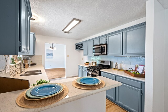 4309 Kingfish Dr, Seabrook, TX 77586 - kitchen featuring stainless steel appliances, a sink, light countertops, and a textured ceiling
