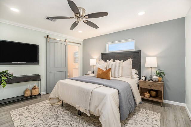1014 11th St, Galveston, TX 77550 - bedroom with wood finish floors, baseboards, ceiling fan, recessed lighting, and a barn door