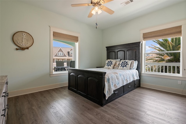 2585 Tide Dr, Crystal Beach, TX 77650 - bedroom with multiple windows, wood finished floors, and baseboards