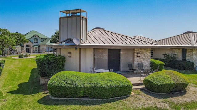 1406 Broken Hls Unit 14, Horseshoe Bay, TX 78657 - back of house featuring a standing seam roof, metal roof, a yard, a patio, and a chimney