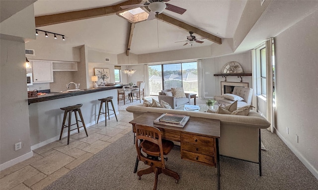 1406 Broken Hls Unit 14, Horseshoe Bay, TX 78657 - living room with beamed ceiling, ceiling fan, stone tile floors, baseboards, and track lighting