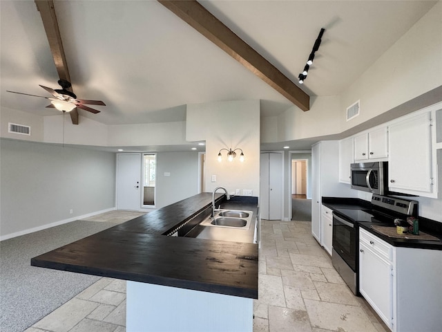 1406 Broken Hls Unit 14, Horseshoe Bay, TX 78657 - kitchen with appliances with stainless steel finishes, dark countertops, stone tile floors, beam ceiling, and high vaulted ceiling