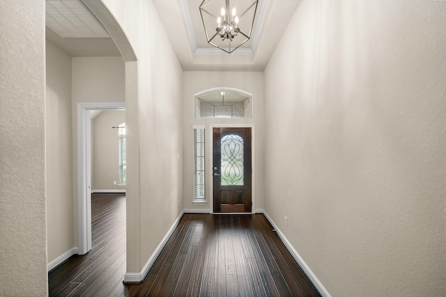 19119 Cardinal Grove Ct, Cypress, TX 77429 - foyer with dark wood-style flooring, arched walkways, a chandelier, a textured wall, and a raised ceiling