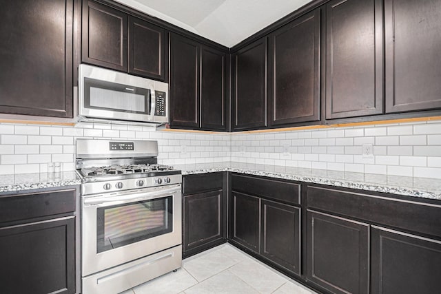 607 Harvest Bluff Dr, Rosharon, TX 77583 - kitchen with appliances with stainless steel finishes, light tile patterned floors, light stone countertops, and tasteful backsplash