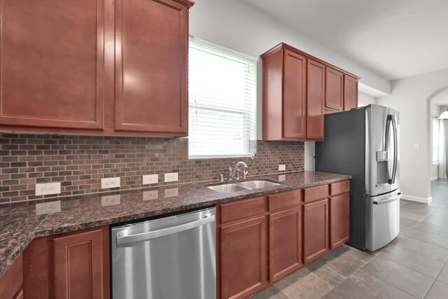 16819 Apple River Dr, Cypress, TX 77433 - kitchen featuring appliances with stainless steel finishes, a sink, backsplash, dark stone countertops, and brown cabinets