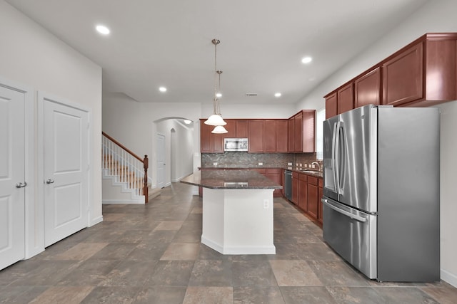 16819 Apple River Dr, Cypress, TX 77433 - kitchen featuring appliances with stainless steel finishes, arched walkways, backsplash, a kitchen island, and a sink