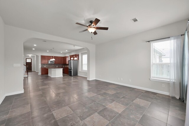 16819 Apple River Dr, Cypress, TX 77433 - unfurnished living room featuring arched walkways, a ceiling fan, baseboards, and recessed lighting