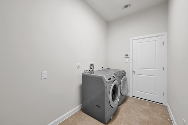 16819 Apple River Dr, Cypress, TX 77433 - laundry room with washer and clothes dryer, baseboards, and light tile patterned flooring