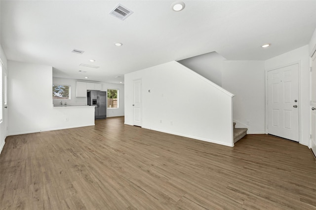24027 Wandering Brook Dr, Hockley, TX 77447 - unfurnished living room featuring stairway, recessed lighting, wood finished floors, baseboards, and a sink