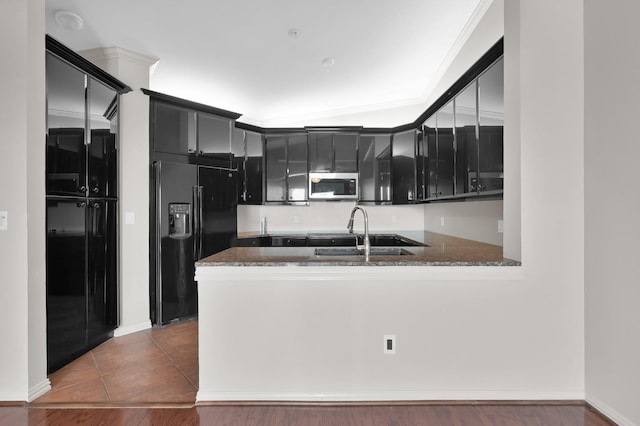2100 Welch St Unit C309, Houston, TX 77019 - kitchen with stainless steel microwave, black fridge with ice dispenser, dark cabinets, and a peninsula