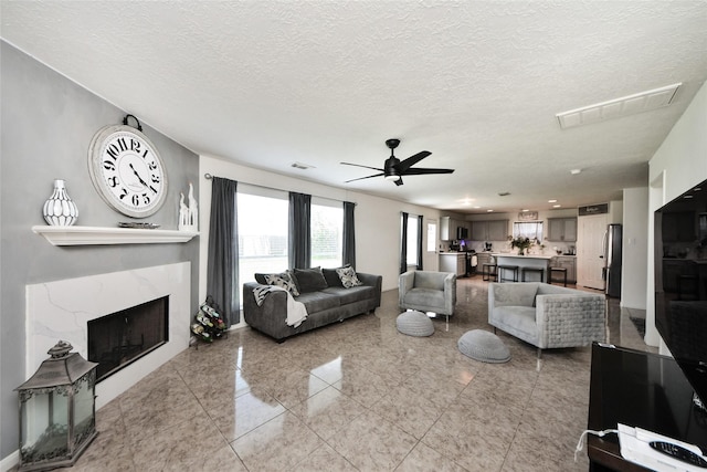 9107 S Ferndale Place Dr, Houston, TX 77064 - living room with a ceiling fan, a premium fireplace, and a textured ceiling