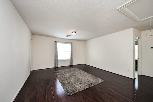 9107 S Ferndale Place Dr, Houston, TX 77064 - unfurnished room with attic access, dark wood finished floors, and a textured ceiling