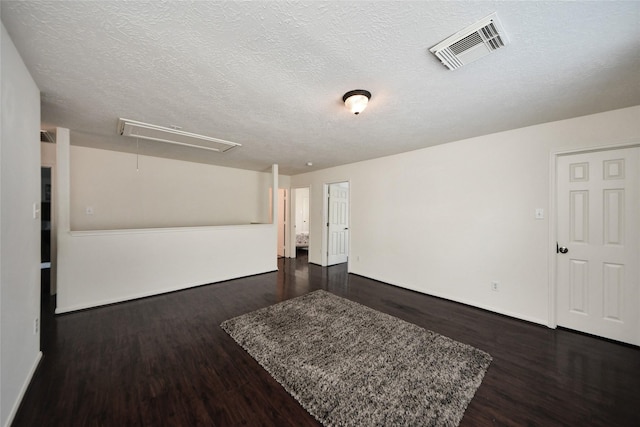 9107 S Ferndale Place Dr, Houston, TX 77064 - unfurnished room with attic access, dark wood finished floors, and a textured ceiling