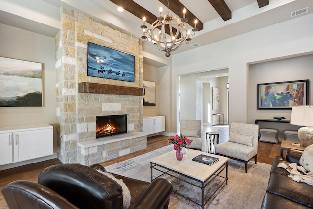 4810 R O Dr, Spicewood, TX 78669 - living area featuring beam ceiling, a stone fireplace, wood finished floors, and a chandelier