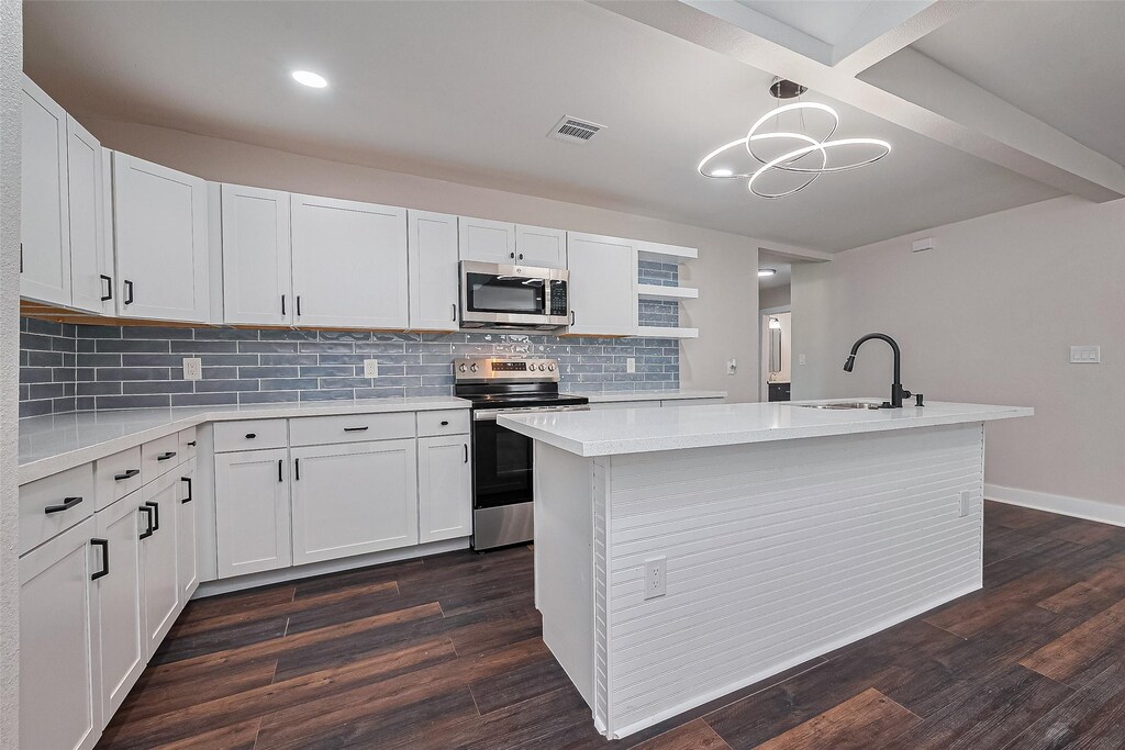 5032 Briscoe St, Houston, TX 77033 - kitchen with appliances with stainless steel finishes, a sink, light countertops, dark wood-style floors, and recessed lighting