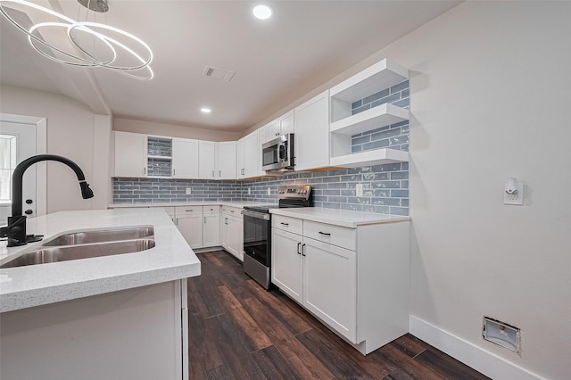 5032 Briscoe St, Houston, TX 77033 - kitchen featuring stainless steel appliances, a sink, open shelves, decorative backsplash, and white cabinetry