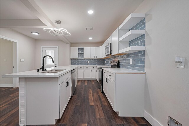 5032 Briscoe St, Houston, TX 77033 - kitchen featuring open shelves, stainless steel appliances, a sink, tasteful backsplash, and a kitchen island with sink